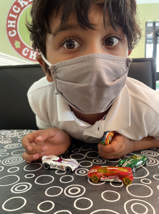 Rayan at the new Chicken Salad Chick restaurant playing with toy cars.