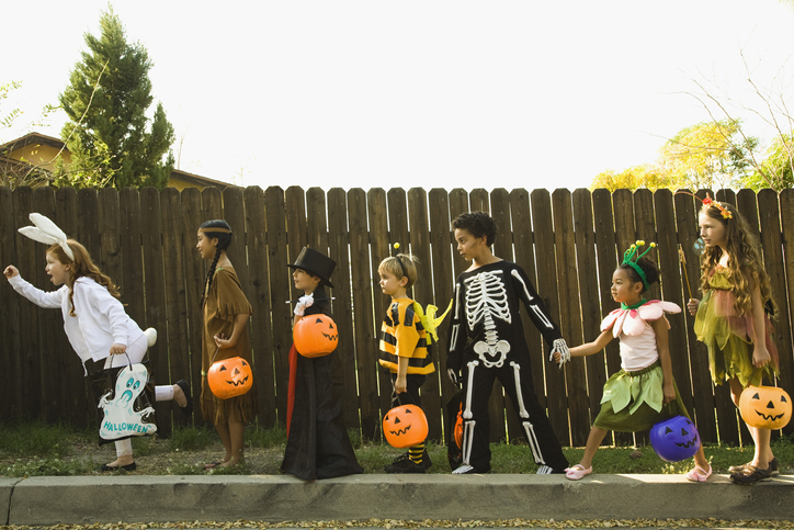 Children in Halloween costumes holding hands about to go Trick-or-Treating