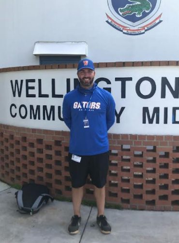 Coach Chris Burnett standing in front  of Wellington Landings Middle School.