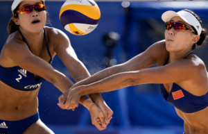 Two Women Playing Beach Volleyball Wearing Bikinis, Ball in Air