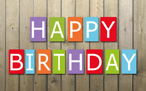 A wooden background with the words happy birthday in decorative font