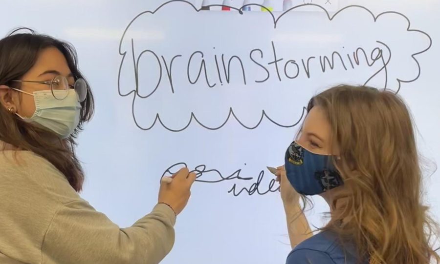 Soha Khan and Lorelei Kelley brainstorming in front of a SMART Board