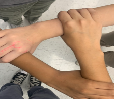 Picture of 3 hands of different skin colors united in a triangle 