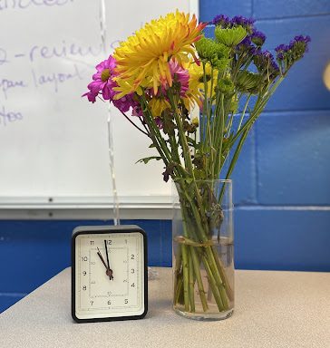 Flowers next to a clock