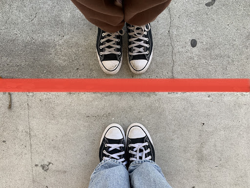 A red line in between two people wearing black shoes