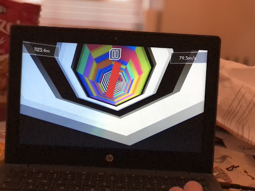Someone playing a game on a chromebook with red obstacles