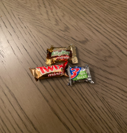 A picture of 3 different types of candies (Twix, 3 musketeers, and a Milky Way). 