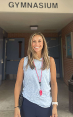 Photo of Ms. Casella in front of WLMS gymnasium 