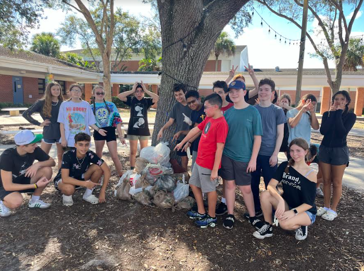Picture of NJHS members who came to the clean up  pointing at all the trash 
