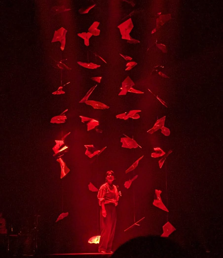 Mitski singing underneath red lights and hanging mirrors.