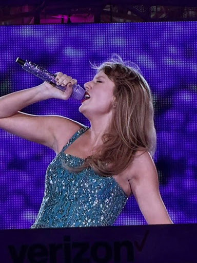 Taylor Swift in a blue sequin dress during The Speak now enchanted.