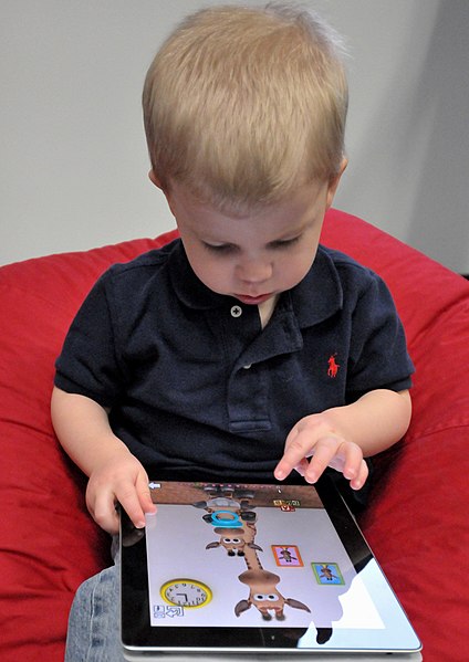 Boy playing with IPad. (Photo by Intel Free Press)