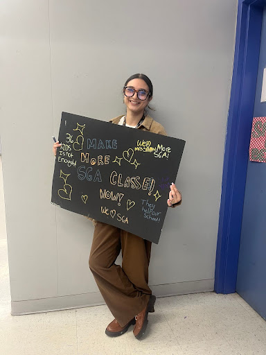 Wellington Landings teacher Mrs Spalla holding a poster.