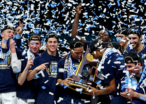 Picture of Michigan Holding the March Madness Trophy